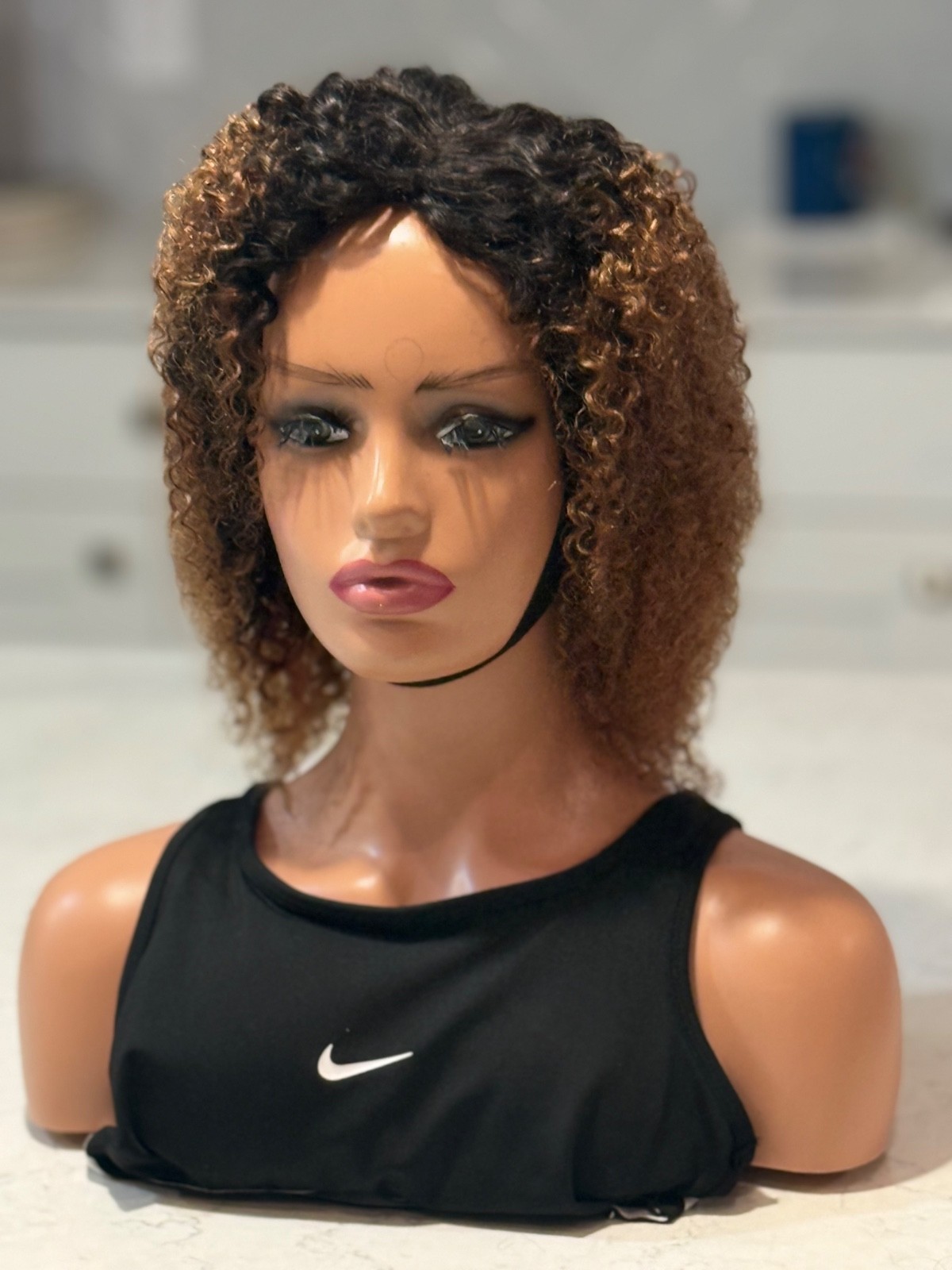 Human hair curly Afro brown wig with a side part.