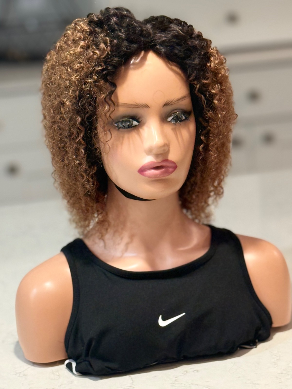 Human hair curly Afro brown wig with a side part.