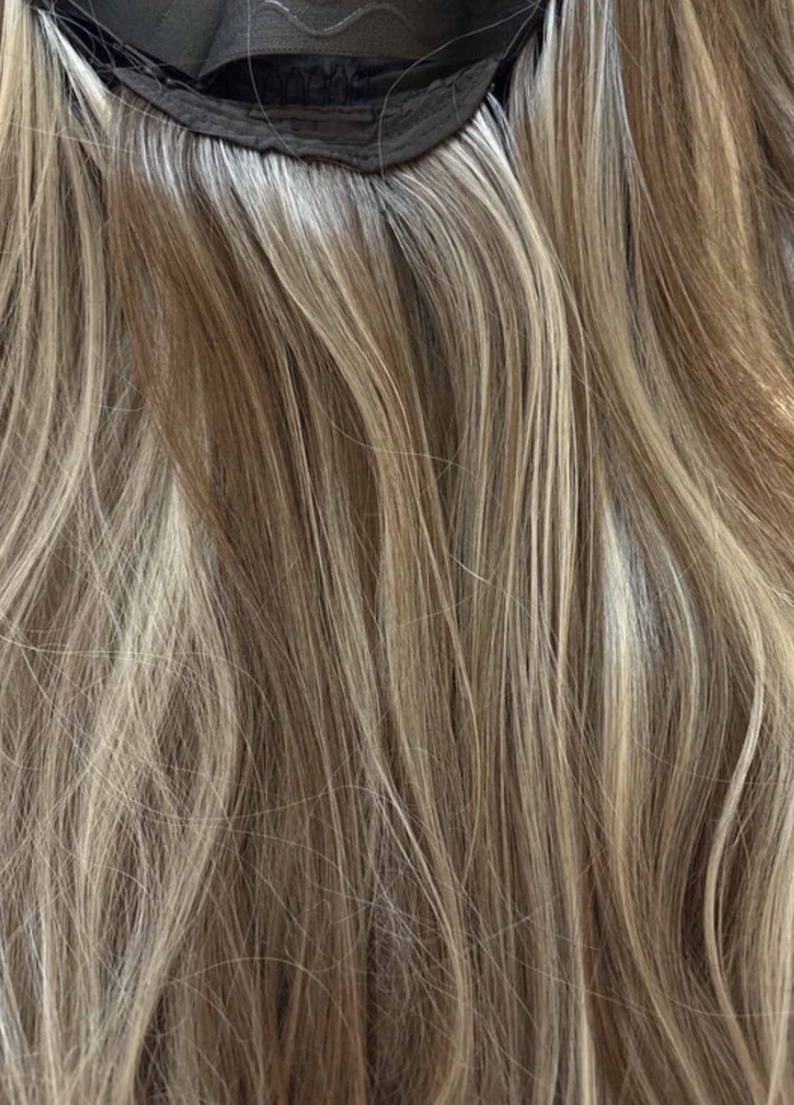 Lady Grayy long, wavy blonde synthetic wig with brown highlights. 26-28”